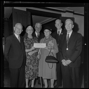 Group of people holding a sign that reads "Reserved for 1889ers"