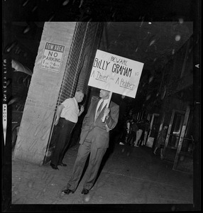 Protester with a sign that reads "Beware Billy Graham a thief and a robber"
