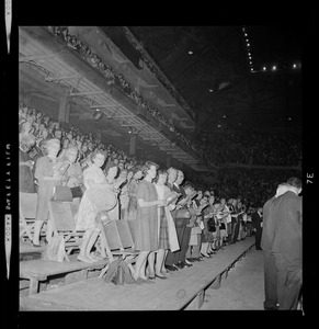 Crowd at Dr. Billy Graham's "Crusade for Christ" at the Boston Garden standing and singing from a songbook