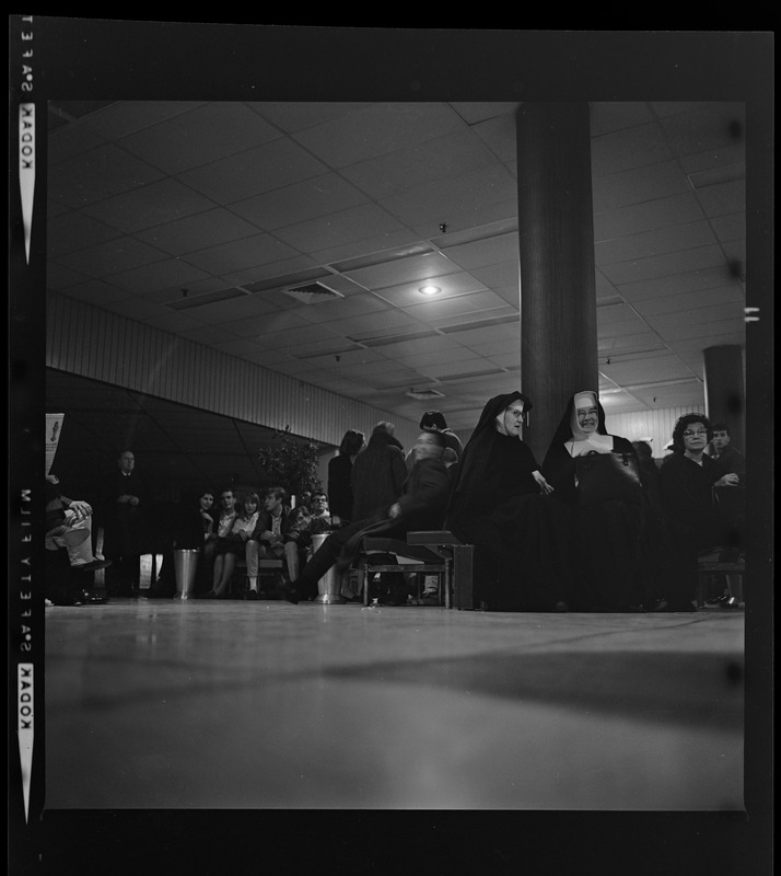 Group of people in a lobby, including religious nuns