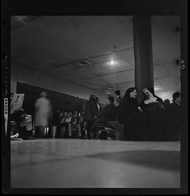 Group of people in a lobby, including religious nuns