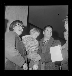 Woman and man holding a child and talking with a reporter