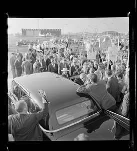 Senator Barry Goldwater entering a vehicle among a crowd of people and reporters