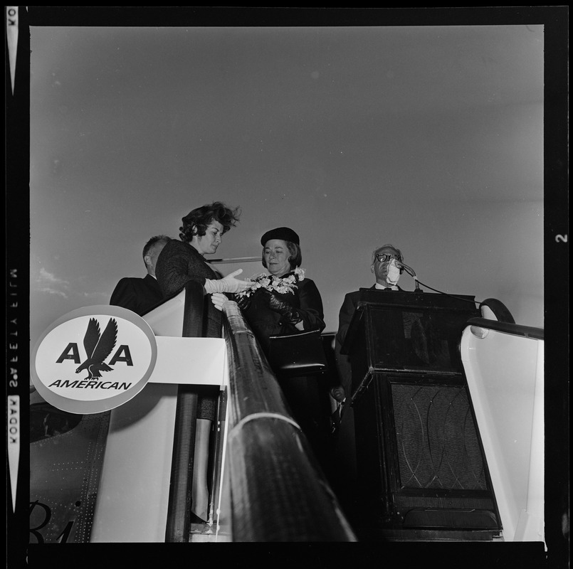 Sen. Barry Goldwater addressing the crowd at the airport from the American Airlines stair ramp of the plane while his wife Peggy receives flowers