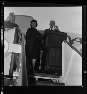 Sen. Barry Goldwater addressing the crowd at the airport from the American Airlines stair ramp of the plane while his wife Peggy looks on