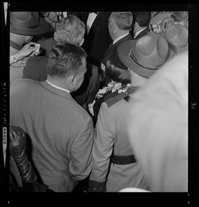 Uniformed officer moving Mr. and Mrs. Barry Goldwater after their arrival to Boston