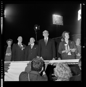 Governor Volpe, left, standing with Sen. Barry Goldwater, center, Peggy Goldwater, right, and others on the stage at Fenway Park