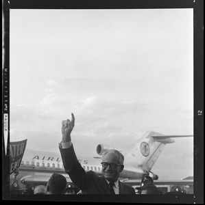 Sen. Barry Goldwater raises arm as he walks off the plane at the airport