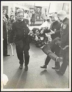 Bystanders Smile as police carry away youth from in front of bus at Boston Army Base.
