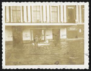No, It Isn't Venice, it's Providence, R. I., after the waters had receded. The dark mark on the front of the Hotel Biltmore in downtown Providence shows how high the flood waters reached at the height of the storm. Firemen are rescuing a woman in the boat in this exclusive Herald picture.