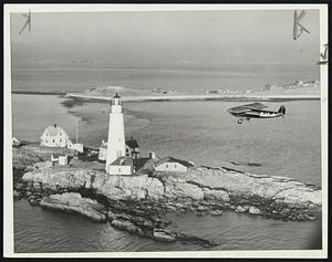 Capt "Bill" Wincapaw the aerial Santa Claus who drops Christmas packages to the light houses annually along the New England coast is here shown as he dropped his first package to the light house keepers on Boston light. This photo made just after sun rise from another plane.