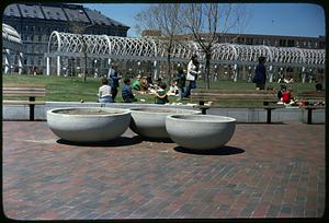 Children sitting and eating on grass, Christopher Columbus Park, Boston