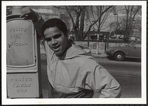 Young man leaning on police cable box