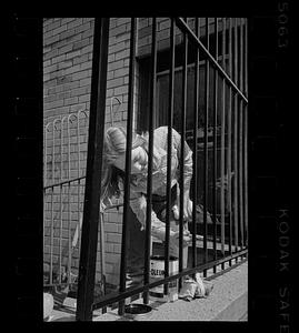 Woman paints railing in Bay Village, Boston