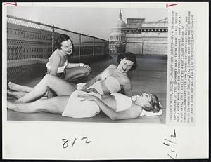 Washington - January Sun Bathers - With Washington Temperatures at the 75-degree mark these three girls tested out a hotel roof near the Capitol (background) today for a sun bath. They are (left to right) Janet Matheson of Edmonton, Alberta: Patty Ann Barnes of Westfield, Mass., and Helen Davidson of Dallas, Tex. Towels were used where bathing suit parts were not available.