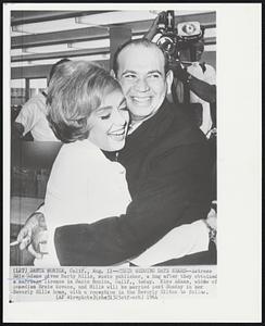 Their Wedding Date Nears -- Actress Edie Adams gives Marty Mills, music publisher, a hug after they obtained a marriage license in Santa Monica, Calif., today. Miss Adams, widow of comedian Ernie Kovacs, and Mills will be married next Sunday in her Beverly Hills home, with a reception in the Beverly Hilton to follow.