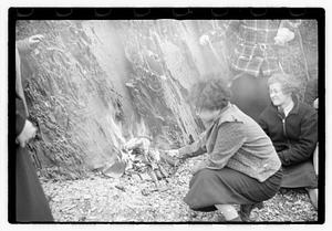 A group of young women cooking food on a fire