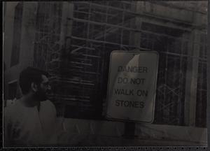 Man looking at a sign in front of building construction