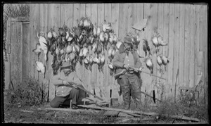 Original title: Wilbur Flanders on left aiming shotgun, right - Harry Ayer showing how to load. Ducks