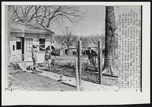 Batten Down for Flood--Three brothers use cables to tie small house down to tree today in readiness for flood from Missouri River. Left to right: Paul, who owns house; Bernard, and Donald Persinger. Paul's family already has been moved to relatives across the river in Sioux City, Ia.