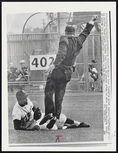 Metropolitan Stadium: Umpire John Flaherty gives emphatic “out” sign as he watches Twins’ right fielder Tony Oliva on ground after he made running, falling catch of pop-up hit by Dodgers’ Lou Johnson in 1st inning.