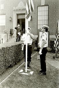 Lt. Louis Addonizio and firefighter Ed Conley raise the flag as Lt. Pat Dunn saluted in the background