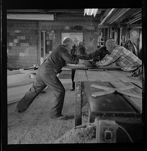 Pert Lowell and others working in boat shop
