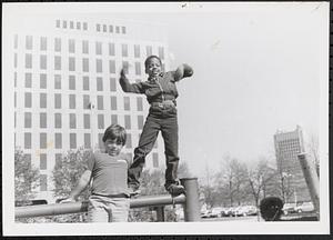 Two boys standing on a railing