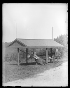 Unidentified older man and older woman sitting under canopy