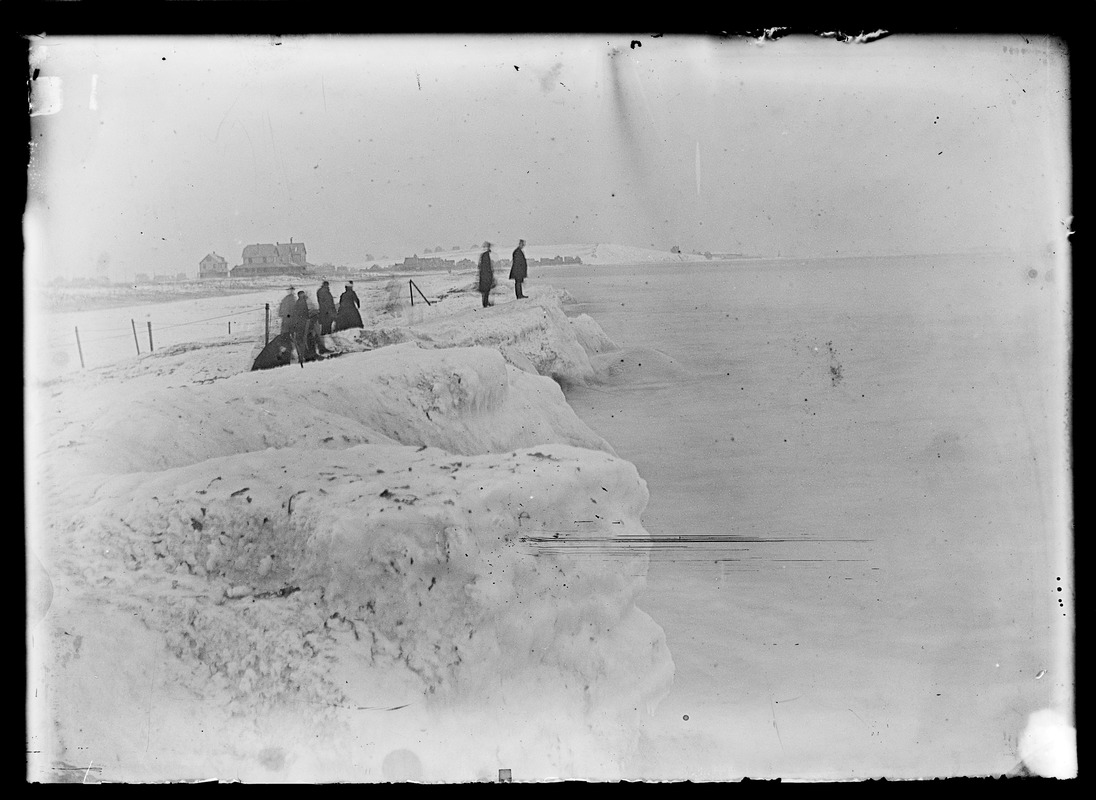 Unidentified group of people along water's edge in winter