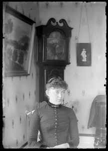 Stella Good sitting in front of grandfather clock