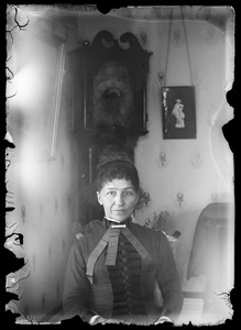 Unidentified woman sitting in front of same grandfather clock