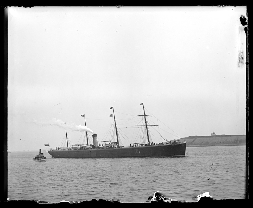 Four masted ship and tugboat in harbor