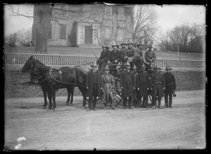 Group of people (firemen) in and around carriage, Main St