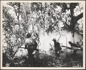 Soldiers of the 1st Infantry Regiment, 6th Division, advance in the Cabaruan Hills, Luzon Island, after throwing several smoke grenades ahead