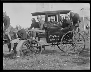 High school football players ride old carriage taxi, possibly Revere