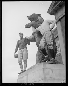 Two Brown players pose with bear statue