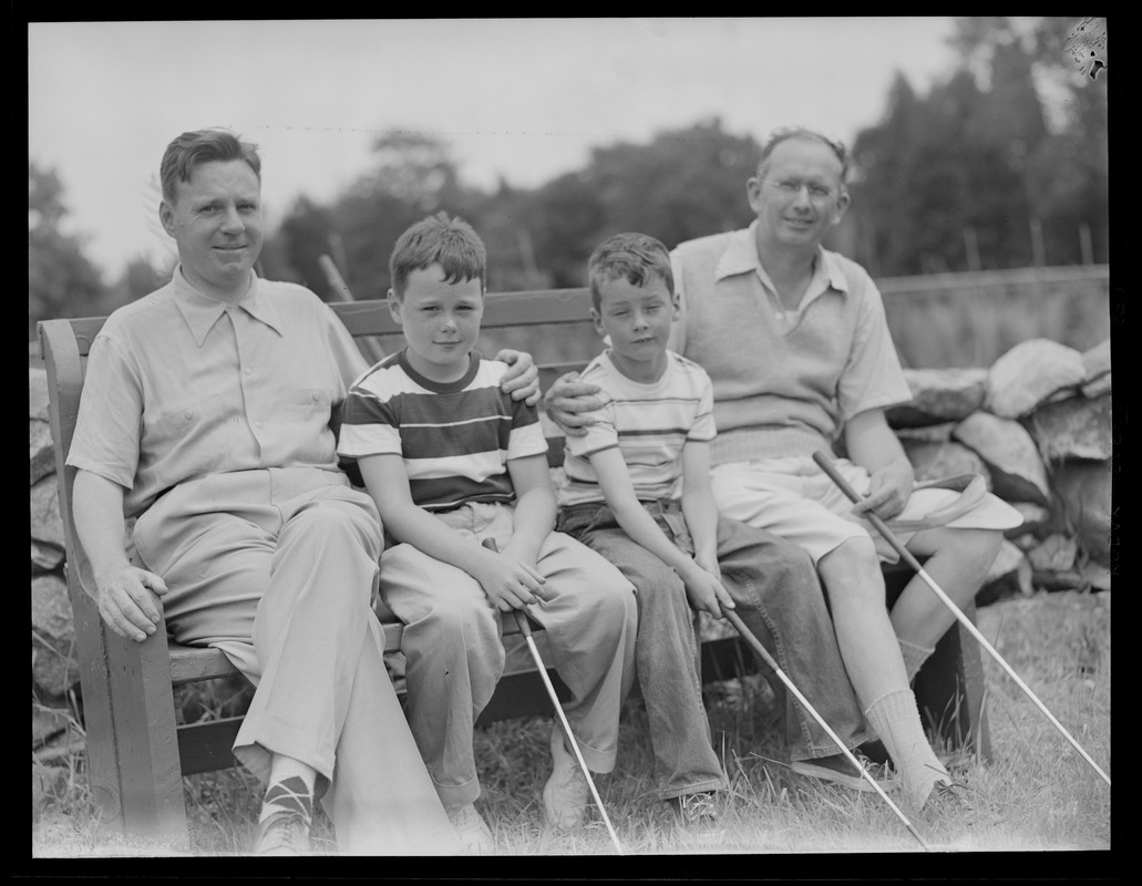 Two men and two boys with golf clubs