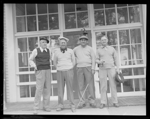 Four golfers pose in front of clubhouse