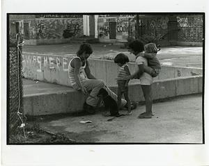 Group of children playing with a puppie in a courtyard