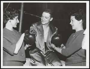 Kid Glove Treatment - Mrs. Jack Drummey, left, of Boston and Mrs. John Driscoll, Jr., of Somerville ready lightweight Bobby Shaughnessy of Dorchester for fight night at University Club by lacing on his gloves.