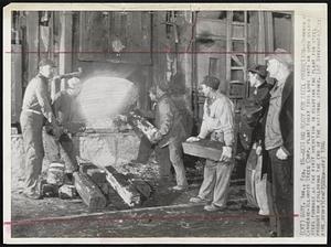 Getting Ready for Steel Production -- Workmen At Carnegie - Illinois Steel Corp. Plant today toss logs into an open hearth steel furnace as the first operation in readying the plant for steel production following the end of the National Strike.