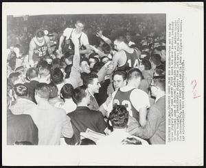 Holy Cross Fans Mob Winners -- Fans mob the Holy Cross players after team scored 75-69 upset win over Western Kentucky in semi-final game of National Invitation Tournament at Madison Square Garden tonight. Identifiable players from left are: Frank Kasprzak (25), Tom Heinsohn (24), Ronnie Perry (14) and Jim Lewis (23), back to camera.