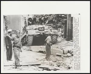 Tank Helps In Quake Cleanup -- Soldiers direct a Yugoslav tank as it flattens rubble in street in Skopje following devastating earthquake of July 26. The stench of death and the threat of an epidemic drove survivors from the shattered city today.