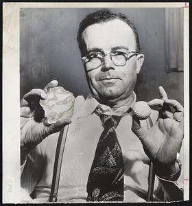 Hailstones Larger Than Golf Balls- Davis Straub (above) of Milwaukee, holding one of each to demonstrate that hailstones which fell during brief storm Monday night were much larger than golf balls. Hailstone shown measured 10.5 inches in circumference. Storm did thousands of dollars worth of damage to greenhouse and windows.