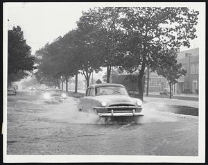 Wet Highway was encountered by cars plowing through flood waters which covered Route 9 at Chestnut Hill yesterday after downpour.