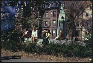People sitting by bust of Patrick Collins, Commonwealth Avenue, Boston Columbus Day Parade 1973