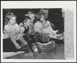 The Emotions Vary -- These five children, all members of the same family, register varying emotions as the watch a television program in the evacuation center at the Lincoln High School gymnasium. Left to right: Three-year-old Eva watches glumly; little Charles, 2, is near tears; Rudy, Jr., 5, stares wide-eyed; and his sister, Rugeina, 4, nonchalantly feeds baby brother Richard, 11-months. The children were evacuated from their flood-threatened home with their parents, Mr. and Mrs. Rudy Punteney