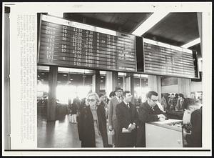 New York – Flight Slowdown at JFK – An airlines departure board indicates flight conditions at JFK airport in New York Monday as passengers line up at reservations desk. Most planes are experiencing equipment delays since aircraft are arriving on limited basis and are not available for turn-around departure flights.