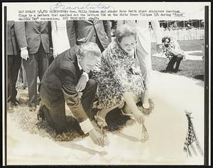 Washington: Rev. Billy Graham and singer Kate Smith miniature American Flags in a pattern that spelled out the letters USA on the White House Ellipse 7/4 during "Honor America Day" ceremonies.